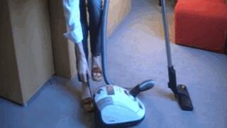 Madame Caren vacuuming carpet in clogs with white vacuum cleaner