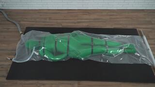 Green nylon zentai suit in a plastic vacuum bag bondage harness