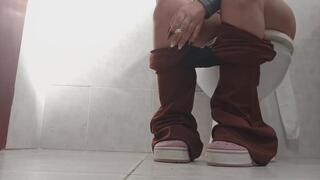 Lola goes to the bathroom and smokes her cigarette.