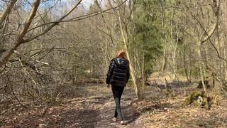 A girl walks barefoot through a spring forest, where mud is ankle-deep