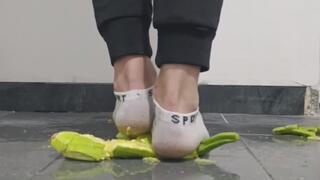 Guy crushing zucchini in ankle white socks