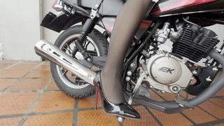 Dalilah struggles to start the motorcycle while wearing high heels