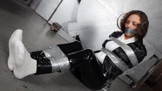 Amber Jonez, in leather outfit, a biker girl captured, taped up, gagged and then tied with ropes to a chair