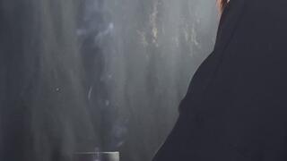 SANDY HE'S SITTING WITH HIS LEGS CROSSED, SMOKING A CIGARETTE.