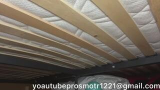 Nastya walks and tramples, jumps, on a large bed and a new mattress, pushing through the slats, they creak and bend under her weight, view from below