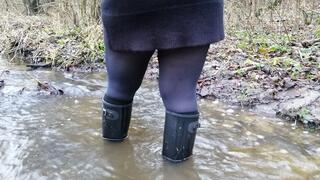 Black rubber boots and a deep stream