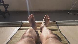 Sunbathing naked male legs.