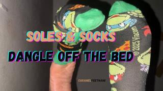 Soles & Socks Dangle Off The Bed