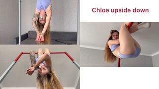 Chloe is hanging upside down, her hands bound and her mouth taped shut