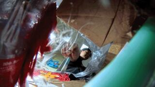 MARTINA throwing garbage into the garbage bag POV