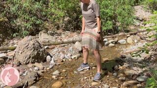 Outdoor piss into a creek