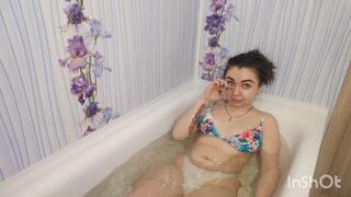 Hottie squishing her belly while lying in the bathtub