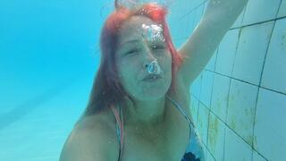 Blowing bubbles underwater in dress