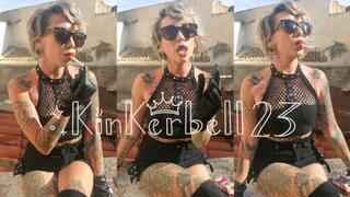 Chain-smoking outdoors wearing Leather gloves and glasses