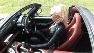 Hot blonde slut in black latex catsuit drives super sport car outdoor