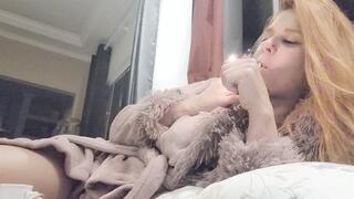 Smoking with dangling cigarette watching tv on couch