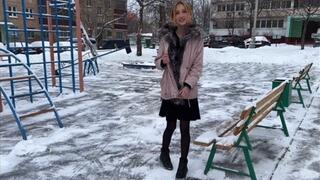 girl having fun on the playground in a summer dress and tights in the snowI
