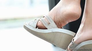 Sandal dangling and perfect feet soles close-up, foot fetish watching