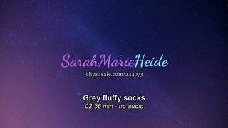 Big girl feet with grey fluffy socks