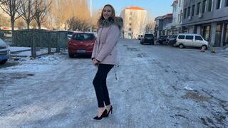 girl decided to walk to the store in high-heeled shoes, but the whole road was covered in ice, her heels were slipping a lot