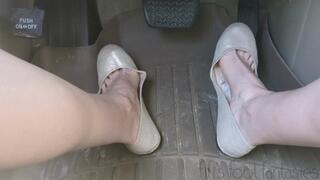 Fifi pumping the pedals of the SUV in a public parking lot wearing sparkly nude ballet flats