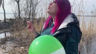 Smoking loner on nature blowing balloon with cigarette
