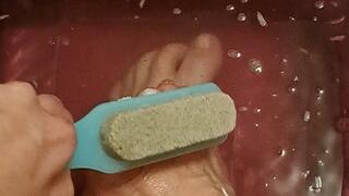Scrubbing feet and toes with a soapy brush