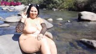 Naked, with cat ears, I masturbate with a giant black dildo in the river