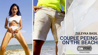 COUPLE PEEING ON THE BEACH