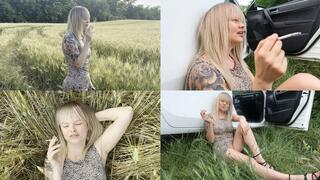 Blonde relaxes in nature and smokes 2 cigarettes