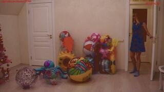 Alla blows off a lot of inflatable toys, squeezing them with her hands with a loud hissing of the air valves