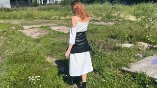 A girl in high-heeled boots with exposed toes walks through puddles and mud and gets her toes and boots dirty, they become dirty and untidy