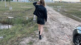 A girl in high-heeled boots walks through very deep mud, mud is poured into the boots and they get wet