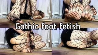 The feet of a gothic girl in large fishnet tights