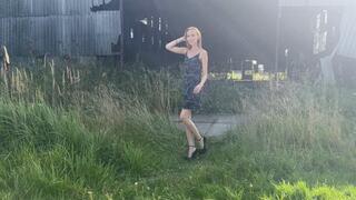 A girl in high-heeled shoes he walks through a landfill with garbage and steps on different garbage