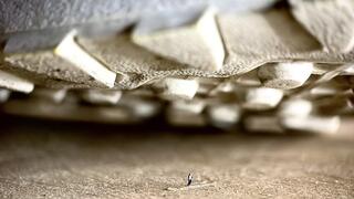 Sneakers and dirty socks of a giantess loom over a tiny guy