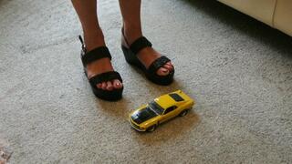 GIANTESS Charn crushes a yellow Ford Boss Mustang in black wedges closeup left view