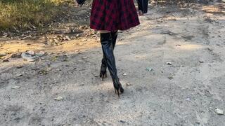 a girl in high heeled boots walks through sticky and viscous mud, sinking her heels into the mud (re-realize)