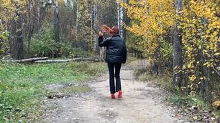 A girl in high-heeled shoes fell and sprained her ankle, she has a difficult path through mountains and potholes