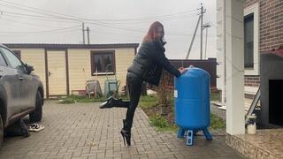 girl in extremely high heels ballet boots walking around the backyard and getting her heels dirty