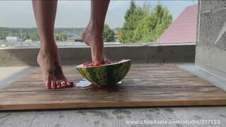 Beautiful feet ruthlessly crushed a watermelon