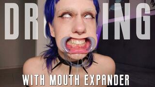 Goth girl's drooling & rolling her eyes with mouth expander