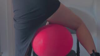 Chubby girl in a dress tries to pop a balloon