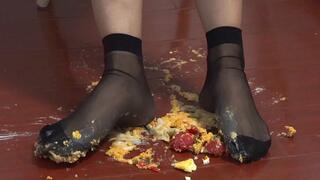 Food Crush - Girl in black stockings crushes cream puffs and tomatoes to prepare your food