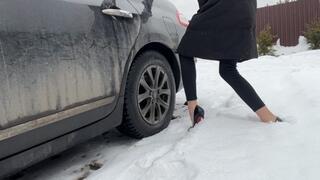 A girl in sexy shoes likes to play with the pedals on someone else's car, she wants to hear a new sound and therefore took someone else's car to press the pedals with her heels and enjoy