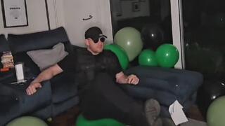 Military Tom Destroys and army of green and black balloons by hand, sit and foot pops