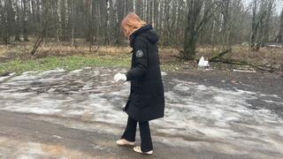 A girl walks in ballet flats on a very bad road where there is slippery ice and slippery mud, her ballet flats slip on such a road and get very dirty