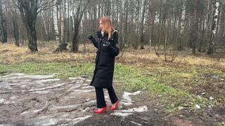 A girl in sexy high-heeled shoes deliberately decided to walk along a dirty forest path, dirtying her heels and destroying them