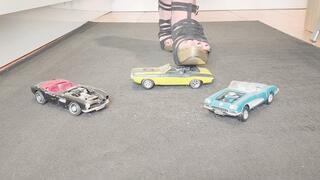 Giantess Raven Lee crushes a 3 classic American convertible toy cars in sexy heels with painted toenails close up ground view
