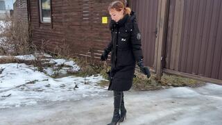 The girl went out for a walk in high-heeled boots, but her heels began to slip heavily on the ice and the girl constantly slips